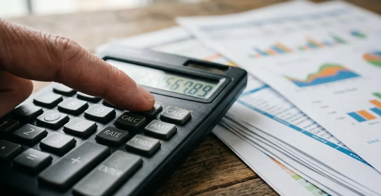 Bureau d'indépendant avec calculatrice et documents financiers pour analyser les charges