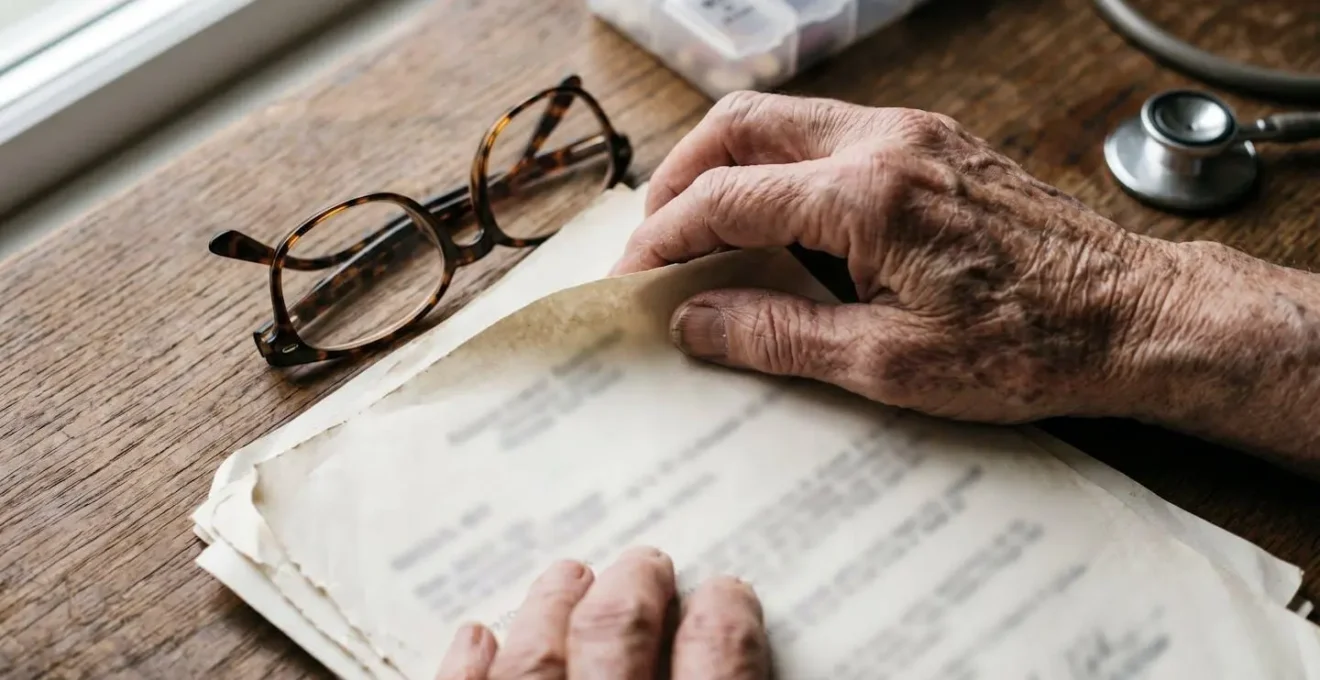 Vue macro de mains remplissant soigneusement un dossier médical avec documents et tests cognitifs