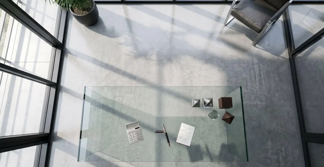 Vue aérienne minimaliste d'un bureau moderne avec documents financiers et calculatrice