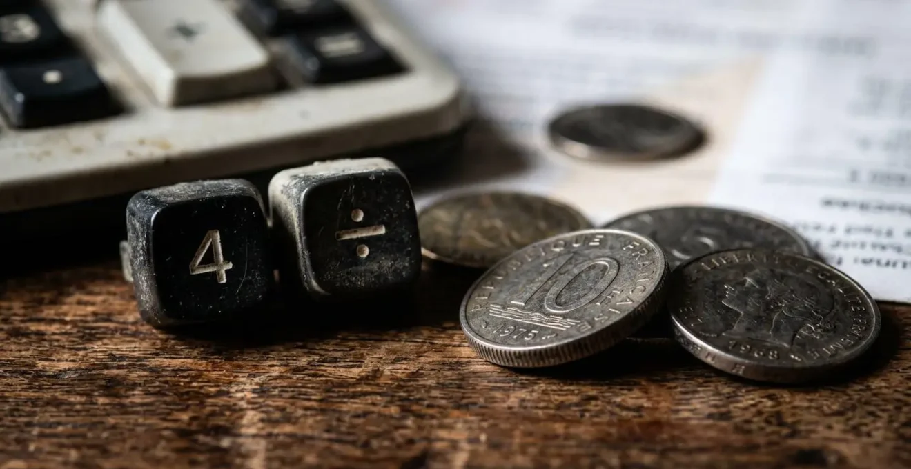 Vue macro d'une calculatrice vintage avec pièces de monnaie et papiers abstraits